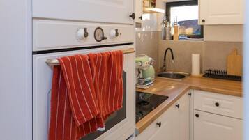 Eine Küche mit Backofen, Spüle und Fenster.