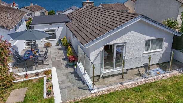 A residential property with a patio, a dining area, and a view of the sea. - 3 Bed in Bull Bay (oc-a45275) (Porth Llechog)