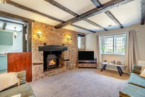 A cozy living room with a stone fireplace, a flat-screen TV, and a comfortable seating area. - 2 Bed in Carhampton (oc-v42711) (Carhampton)