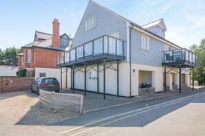 A two-story residential building with a balcony, a garage, and a driveway. - 2 Bed in Old Hunstanton (oc-b44902) (Hunstanton)