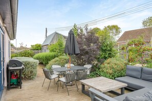 An outdoor patio with a table and chairs, a barbecue grill, and a sofa. - 3 Bed in Hunstanton (oc-b44904) (Hunstanton)