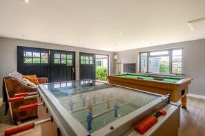 A room with a foosball table, a pool table, and a sofa. - 3 Bed in Hunstanton (oc-b44904) (Hunstanton)