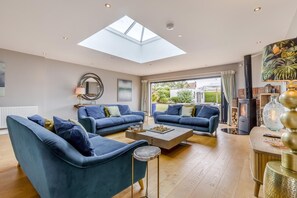 A spacious living room with a skylight, two sofas, a coffee table, and a fireplace. - 4 Bed in Hunstanton (oc-o44907) (Hunstanton)