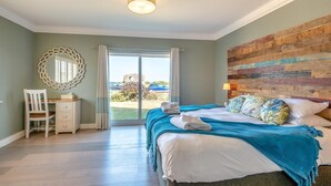 A hotel room with a bed, a desk, a chair, a large mirror, and a view of the outside. - 4 Bed in Hunstanton (oc-o44908) (Hunstanton)