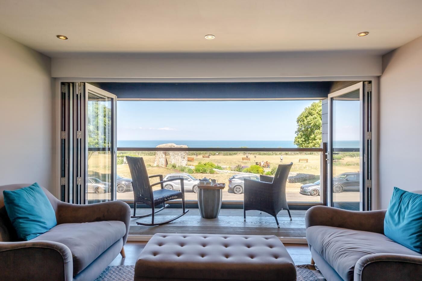 Ein Zimmer mit Meerblick, zwei Sofas, ein Couchtisch und zwei Sessel.