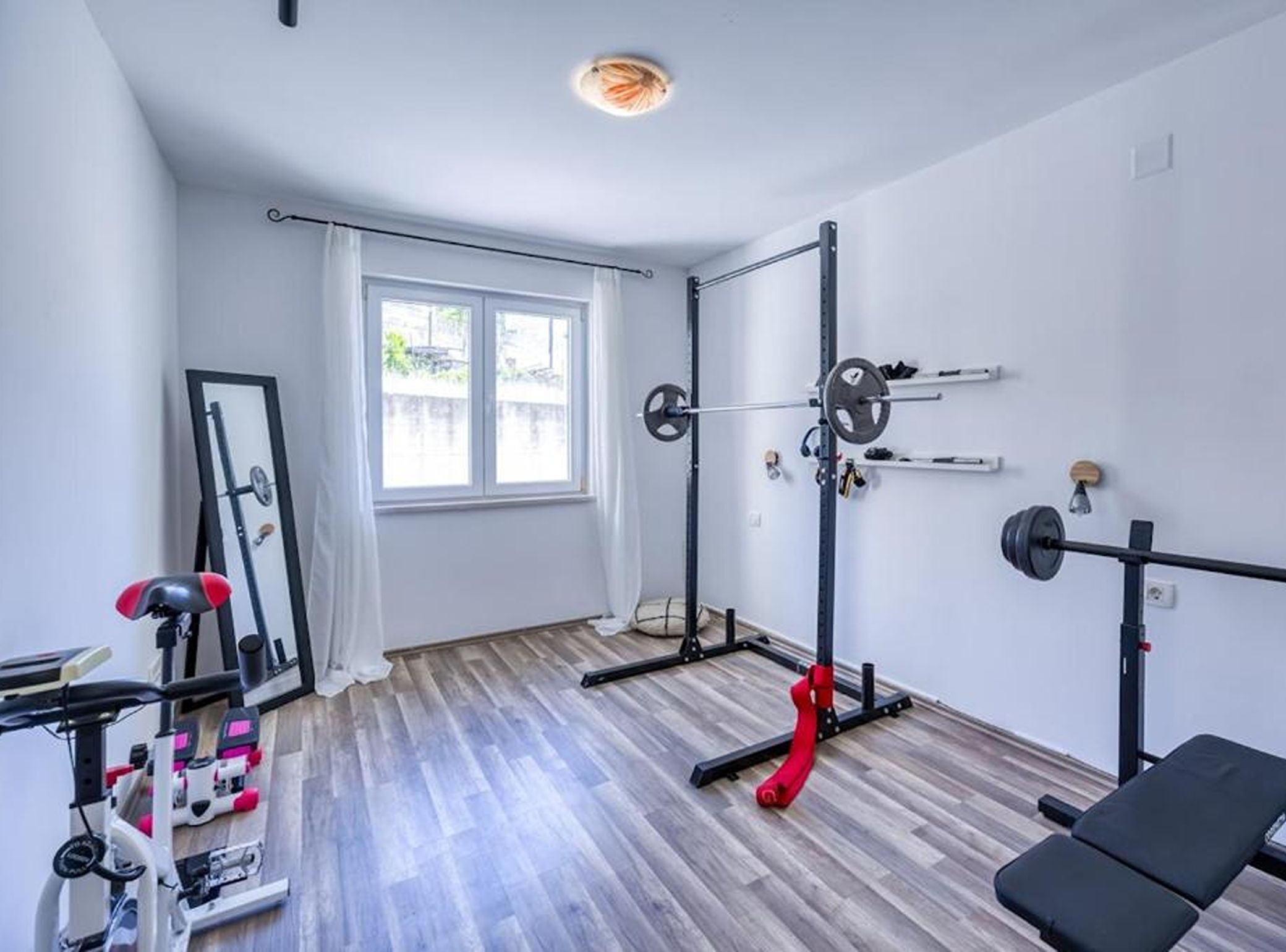 Un gimnasio con barra de dominadas, banco de pesas y equipo de ejercicio.
