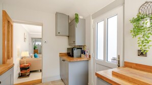 Una cocina compacta con microondas, un mueble pequeño y una encimera de madera.