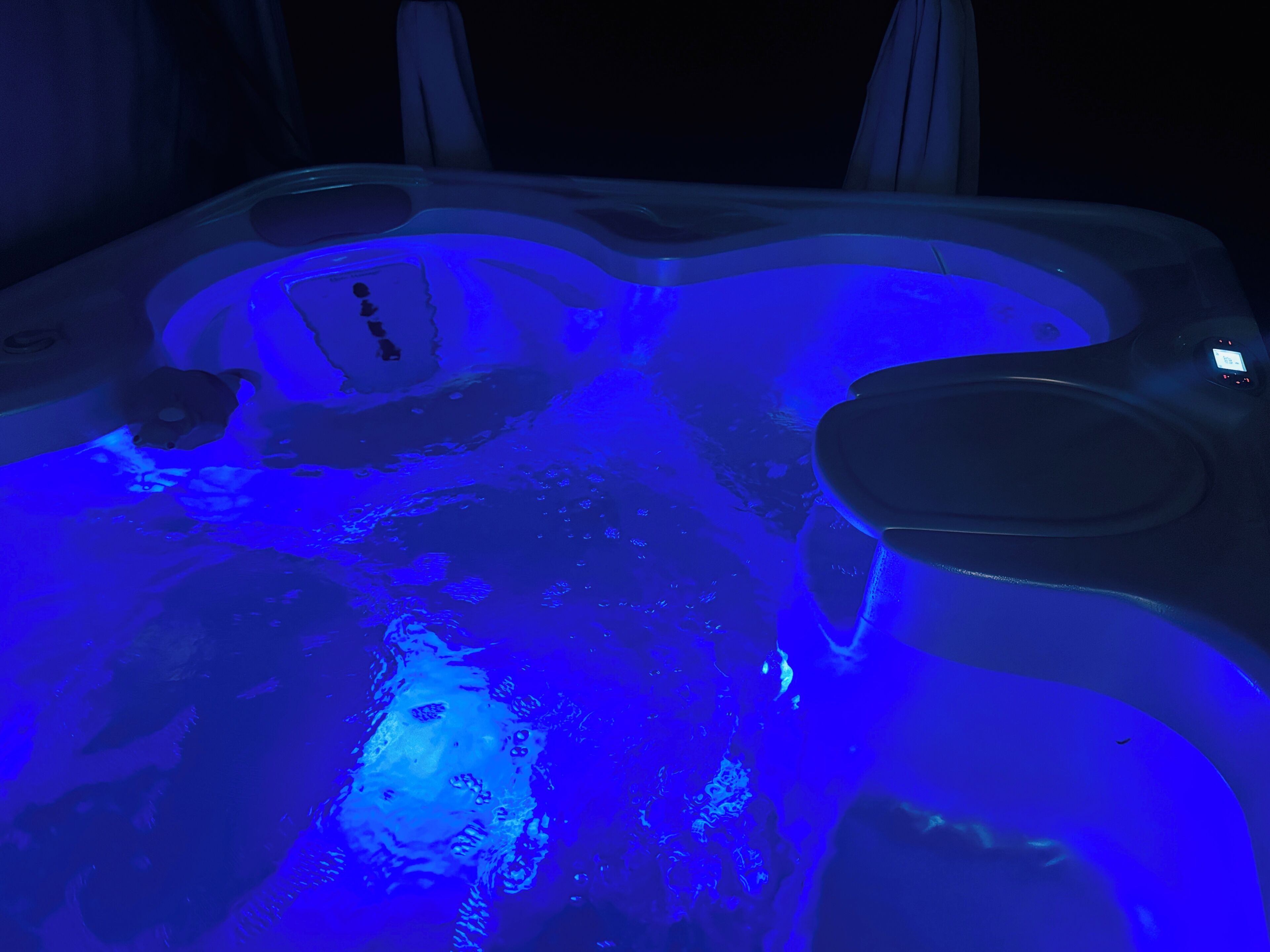 Un bain à remous équipé d’un panneau de commande et d’un espace pour s’asseoir.