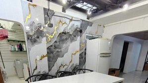 Une cuisine moderne avec un dosseret en marbre, un plan de travail blanc et un meuble encastré.