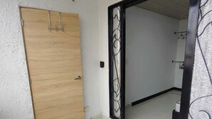Une pièce dotée d’une porte en bois, d’un sol carrelé et d’un grand miroir orné d’un cadre décoratif.