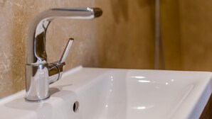 Un lavabo de salle de bain avec un robinet moderne et un miroir.