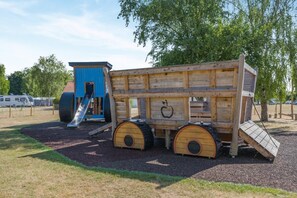 A playground with a wooden play structure, including a slide and a playhouse.