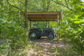 A vintage car parked under a wooden shelter in a wooded area. - 1 Bed in Banham (oc-c1899) (Banham)