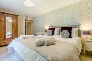 Une chambre à coucher avec un grand lit, une armoire et un miroir.