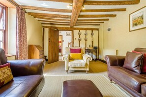 A cozy living room with leather sofas, a central armchair, and a herringbone ceiling. - 4 Bed in Newchurch (oc-bow333) (Newchurch)