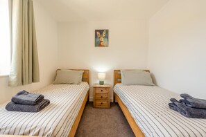 A twin room with two beds, a nightstand, a lamp, and a painting on the wall. - 6 Bed in Meidrim (oc-b45396) (Meidrim)