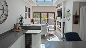 Una cocina moderna con tragaluz, un reloj grande y un comedor con vistas.