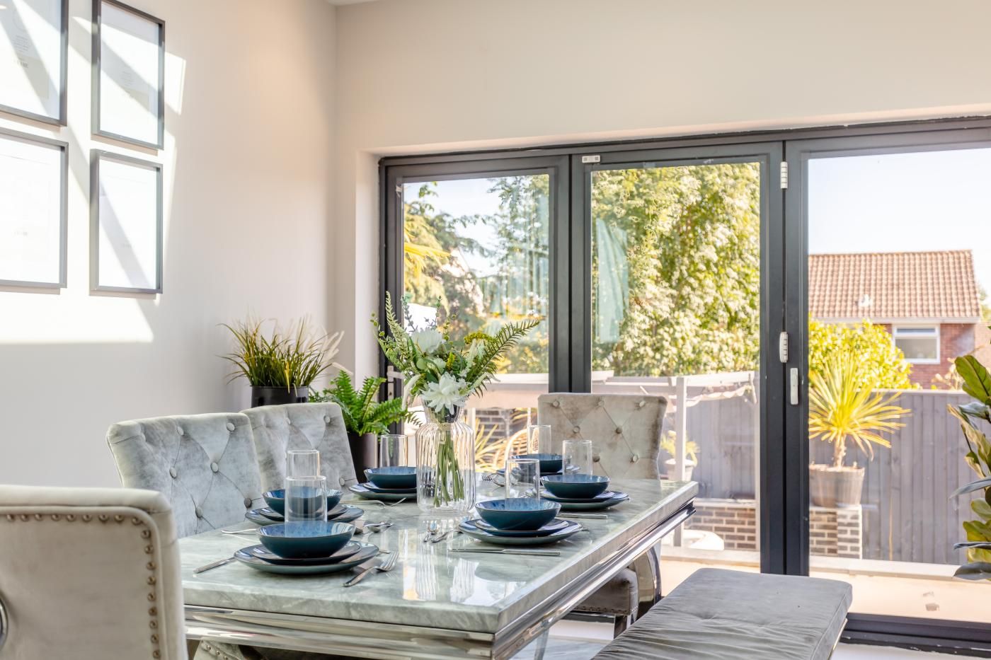 A dining area with a marble table, chairs, and a view through a sliding glass door.