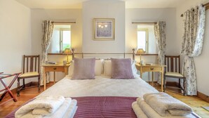 A bedroom with a large bed, two bedside tables, a chair, a window with curtains, and a framed picture on the wall. - 2 Bed in Thornton Rust (oc-t45331) (Thornton Rust)