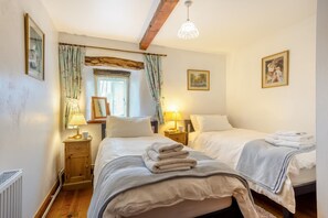 A bedroom with two beds, a window with curtains, a radiator, and a picture on the wall. - 2 Bed in Thornton Rust (oc-t45331) (Thornton Rust)