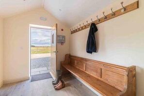 A room with a wooden bench, a coat rack, and a door leading outside. - 1 Bed in Marishes (oc-v45394) (Marishes)