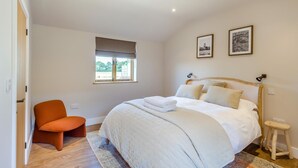 A bedroom with a bed, a chair, a window, and two framed pictures on the wall. - 2 Bed in Bardwell (oc-d44861) (Bardwell)