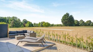 An outdoor seating area with a sofa and chairs, a small table, and a pergola. - 2 Bed in Bardwell (oc-d44861) (Bardwell)
