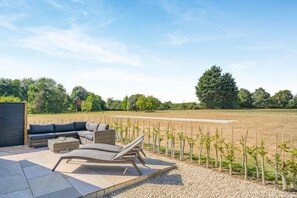 An outdoor seating area with a sofa and chairs, a small table, and a pergola. - 2 Bed in Bardwell (oc-d44861) (Bardwell)