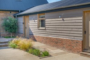A single-story building with a brick foundation and horizontal siding.