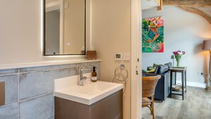 Une salle de bain avec un lavabo blanc, un miroir et un porte-serviette.