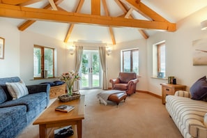 A spacious living room with a high ceiling, a fireplace, and a view of the outdoors through large windows. - 2 Bed in Sawdon (oc-w45349) (Sawdon)