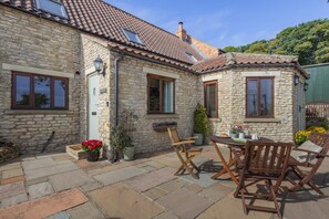 A stone house with a tiled roof, outdoor seating, and potted plants. - 2 Bed in Sawdon (oc-w45349) (Sawdon)