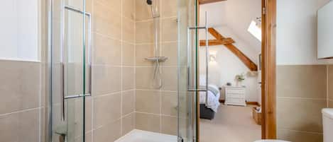 Un baño con ducha envuelta en cristal, bañera y retrete.