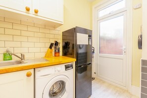 A compact kitchen with a washing machine, a refrigerator, and a sink. - 2 Bed in Eastbourne (oc-e44809) (Eastbourne)