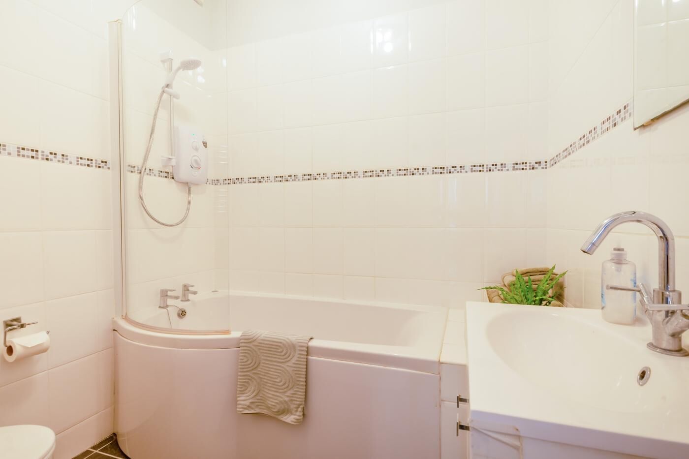 A bathroom with a shower, a bathtub, a toilet, and a sink.