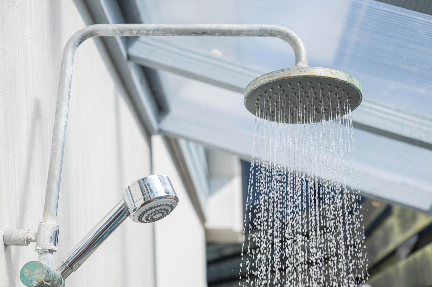 Un soffione con acqua che scorre, fissato a una parete.