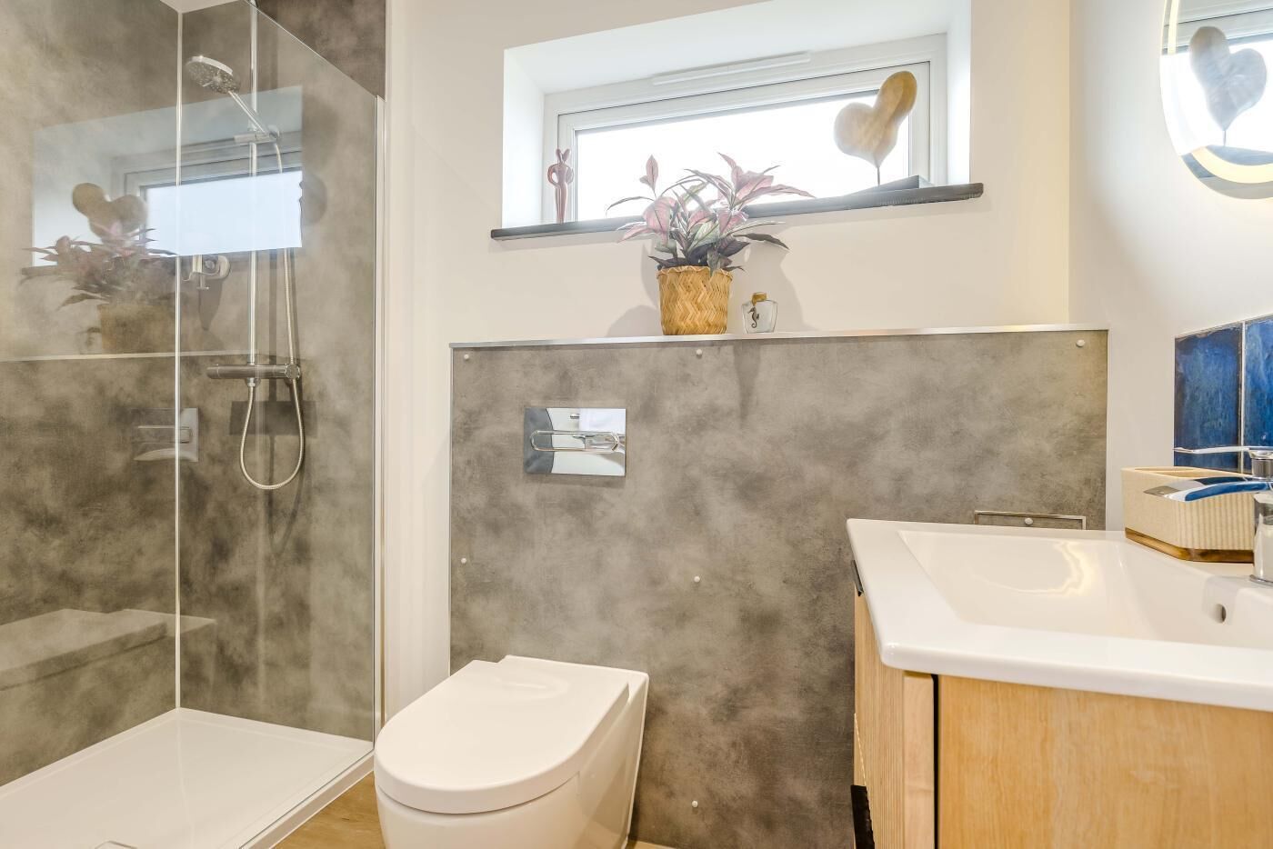 A modern bathroom with a shower, toilet, and vanity.