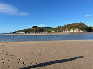 A beach with footprints in the sand, a clear sky, and a hill in the background. - 2 Bed in Kingston (oc-s43307) (Kingston)