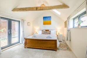 Ein Schlafzimmer mit einem hölzernen Bett, einem Oberlicht, einem großen Fenster und Blick ins Freie.