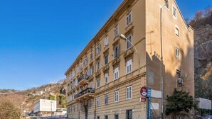 A multi-story building with a classic architectural style, featuring balconies and a prominent entrance. - Two Bedroom Apartment near Centar (Rijeka)