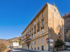 Ein mehrgeschossiges Gebäude im klassischen Stil, mit Balkonen und einer markanten Eingangspforte.