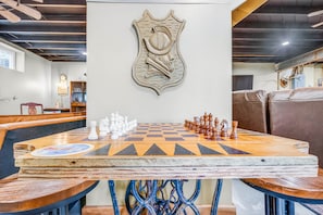 A chessboard set on a table with a coat of arms above it, surrounded by leather seating.