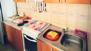 A kitchen with a sink, a dish rack, and various utensils on the wall. - Two Bedroom Apartment with Terrace and Sea View (Vir)