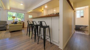 Un'ampia zona giorno con cucina, sgabelli da bar, divano e tavolo da pranzo.