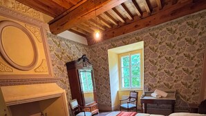 A room with two beds, a fireplace, a mirror, and a window.