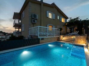 A two-story house with a swimming pool, air conditioning units, and a balcony with a railing. - Two Bedroom Apartment with Terrace and Pool (Trogir)
