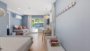 Une chambre d’hôtel moderne équipée d’un lit, d’un canapé, d’un bureau et offrant une vue sur l’extérieur.