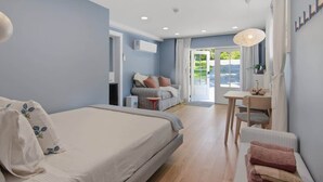 Une chambre à coucher avec un lit, une petite table, une chaise et un canapé.