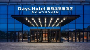 Exterior do Days Hotel by Wyndham, com entrada moderna e sinalização iluminada.