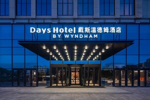 Exterior del Days Hotel by Wyndham con una entrada moderna y señalización iluminada.